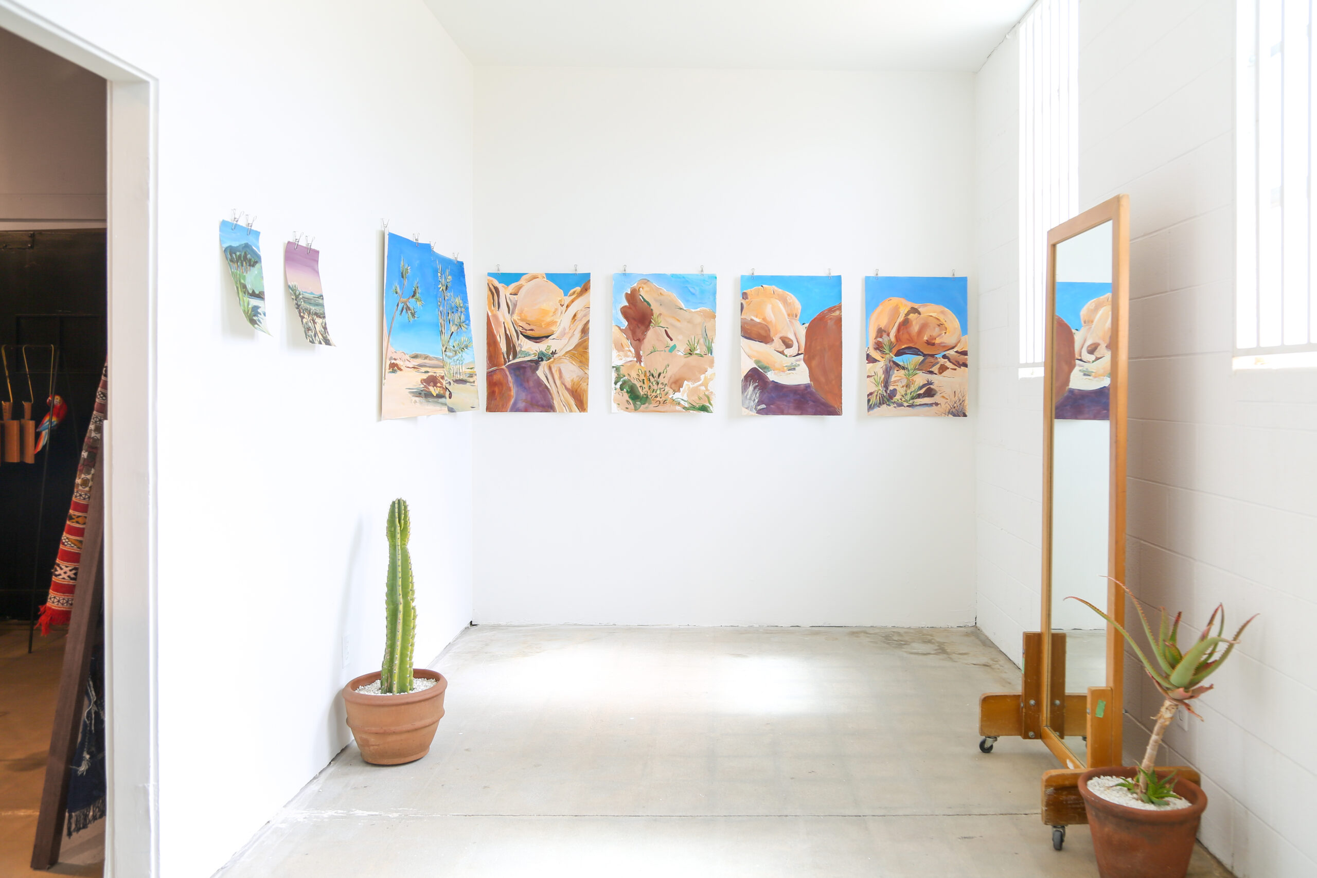 Paintings on display against a white wall gallery by artist Steven Weinberg.