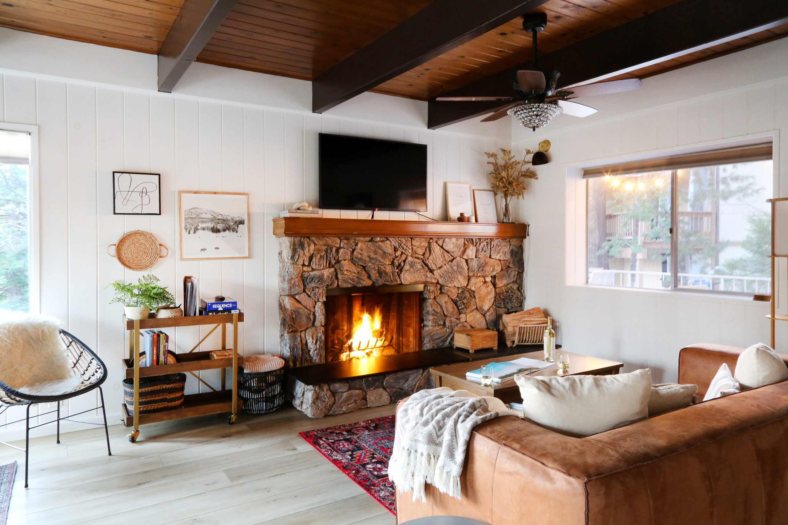Living room with large stone fireplace at Casa Cabina AirBnb vacation rental in Lake Arrowhead, California.