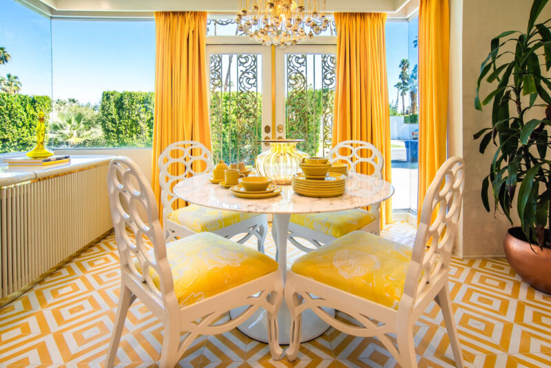 Interior of a vintage yellow and white dining nook in a Palm Springs vacation rental home called the Swinging Sixties.