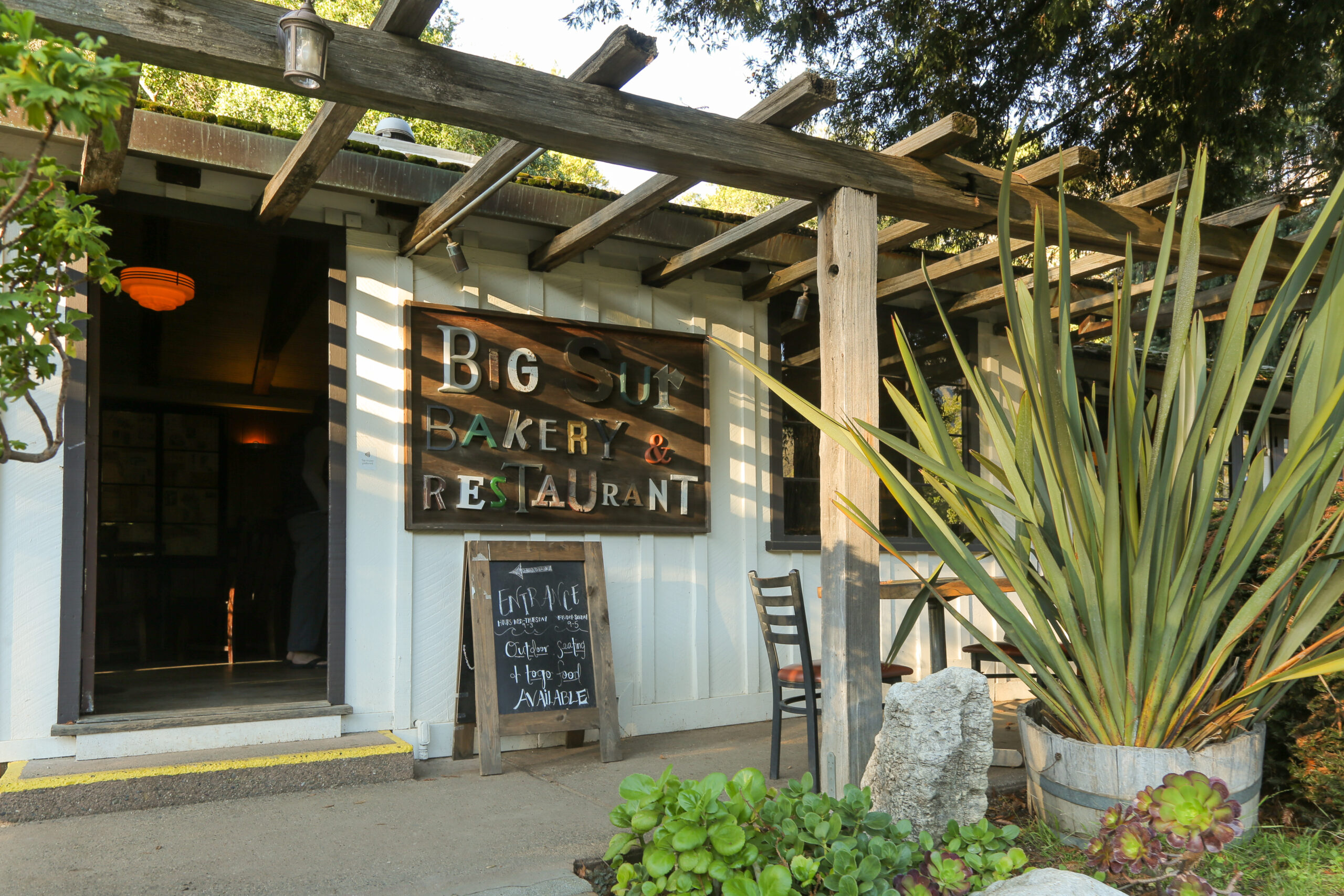Exterior of Big Sur Bakery including the sign and outdoor seating area.