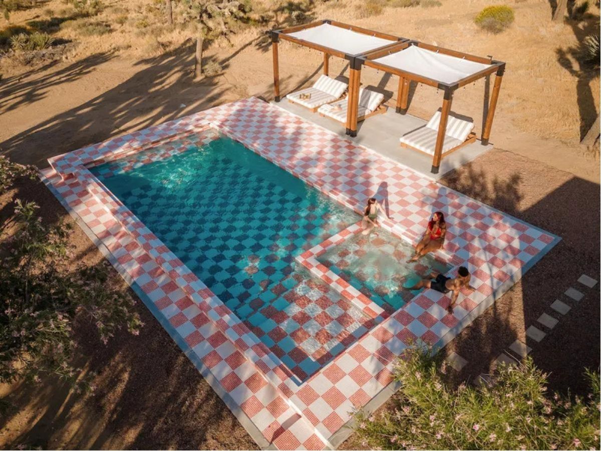 Birds eye view of the white and red checkered pool and hot tub at Stay Wyld Desert vacation rental near Joshua Tree National Park, California.