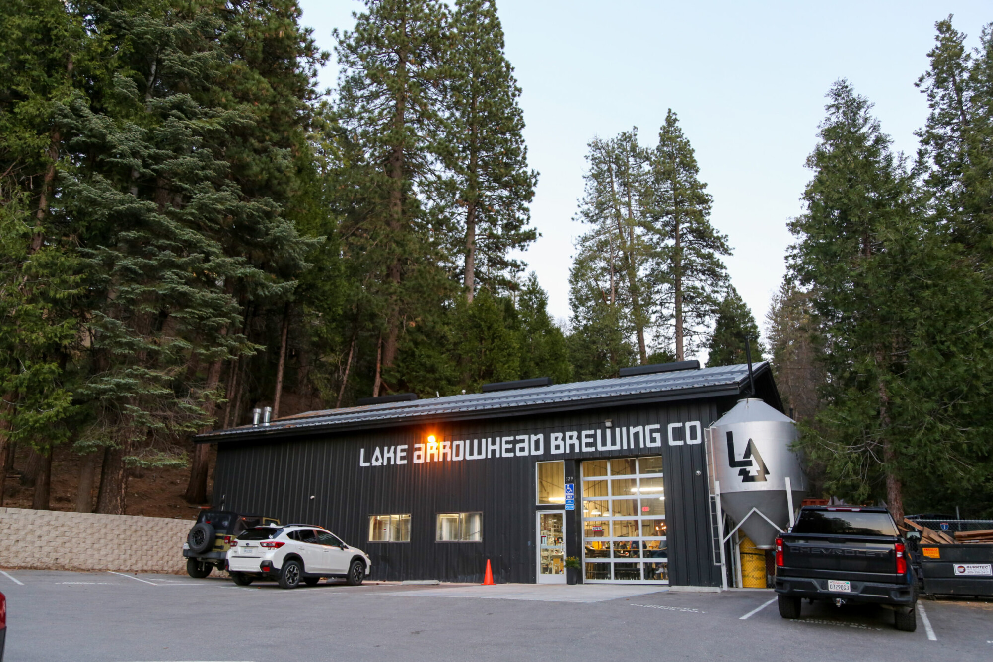 Exterior view of Lake Arrowhead Brewing Company building tucked against a conifer forest in Lake Arrowhead, California.