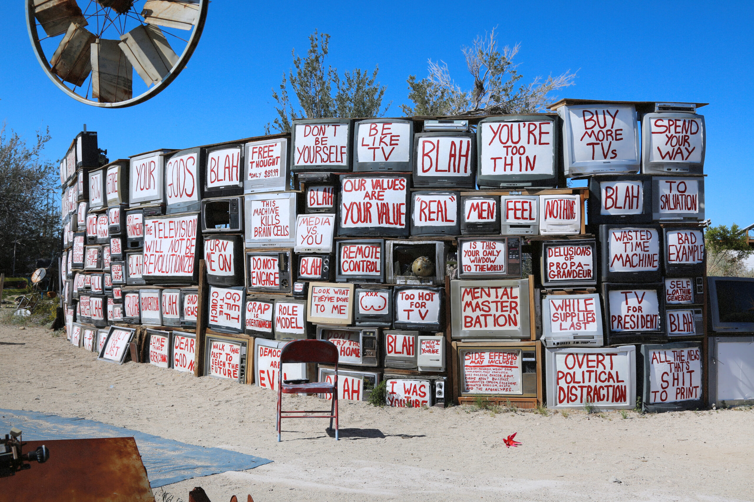 Outdoor art installation of messages painted on old television sets in East Jesus, California.