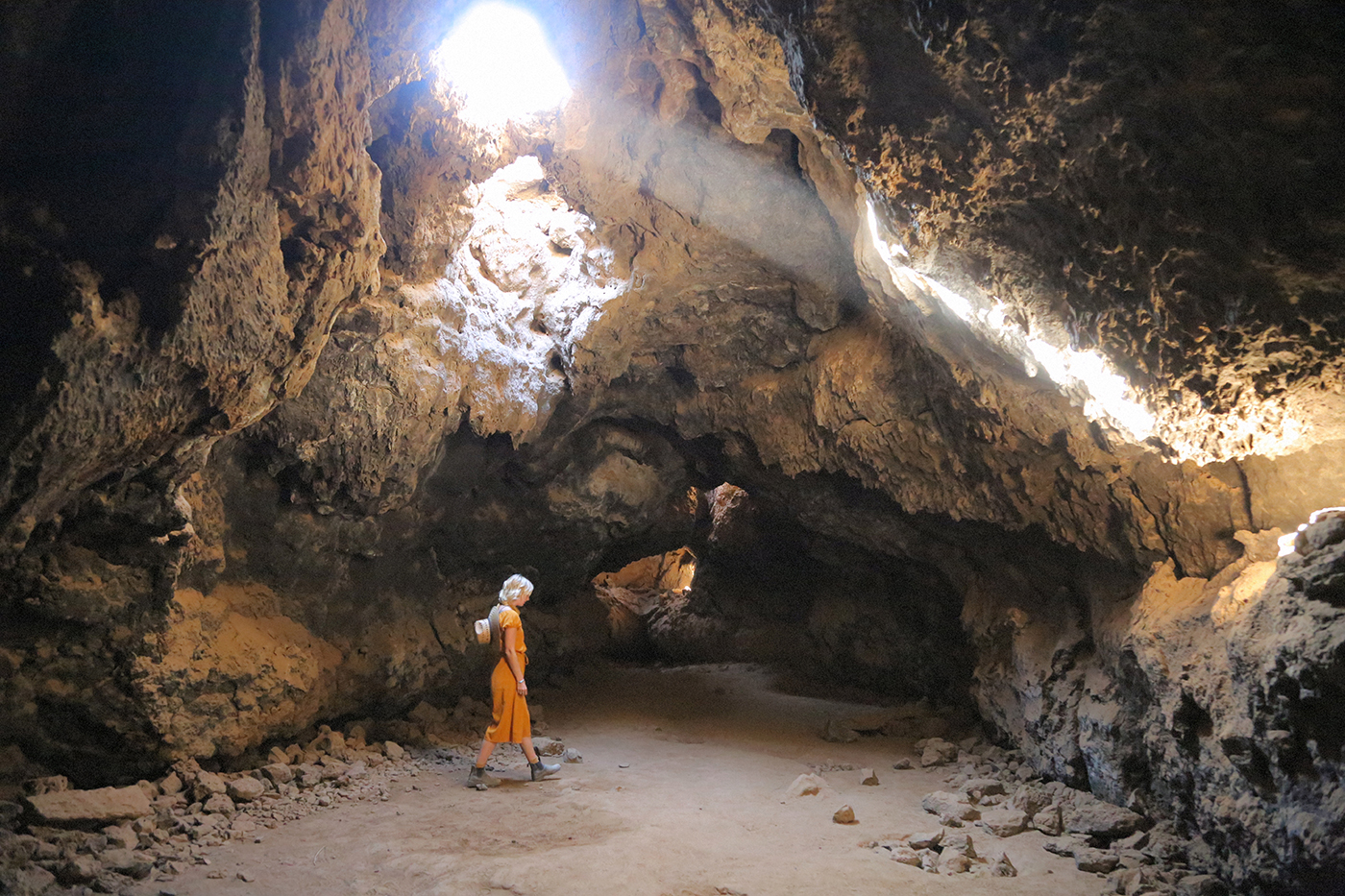 A woman walking through some lava tubes in Mojave National Preserve, California.