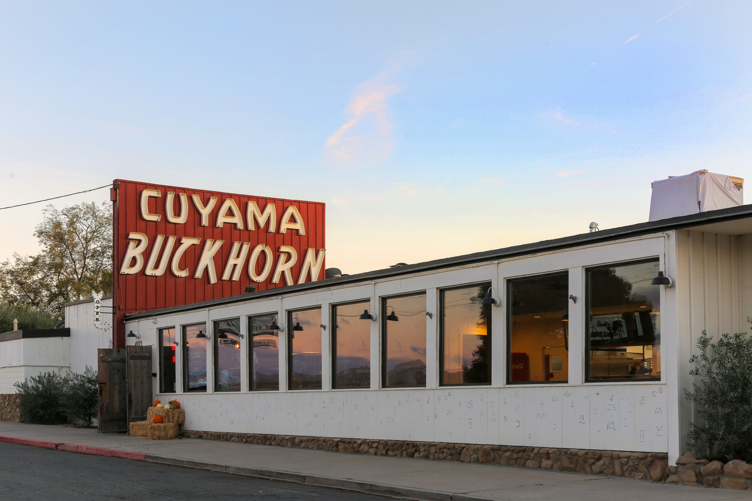 Exterior view of the Cuyama Buckhorn including a prominent orange and white sign reading 'Cuyama Buckhorn' in New Cuyama, California.
