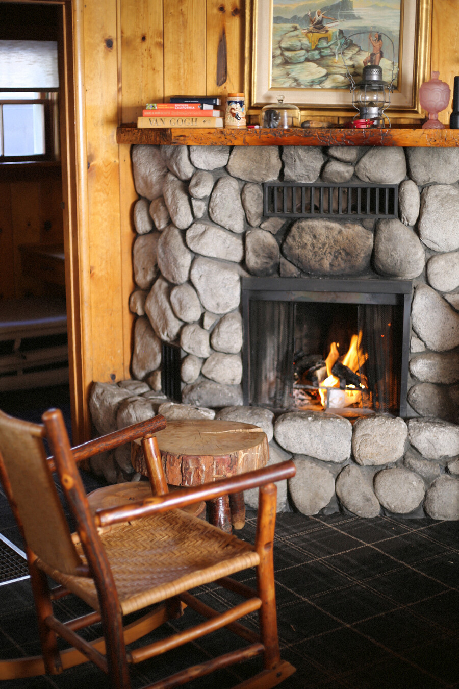 A rocking chair next to a stone fireplace at the Fireside Inn in Idyllwild, California.