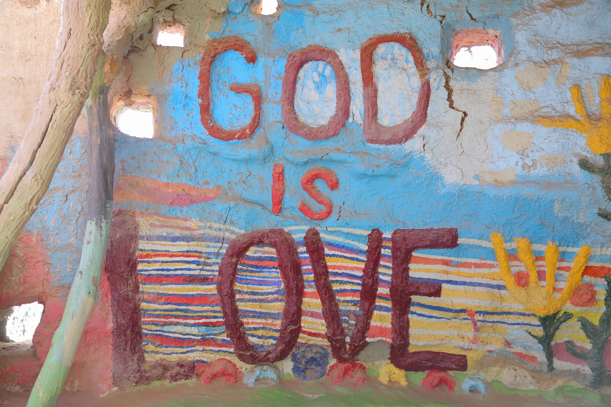 A hand painted wall reading 'God is Love' at Salvation Mountain, California.