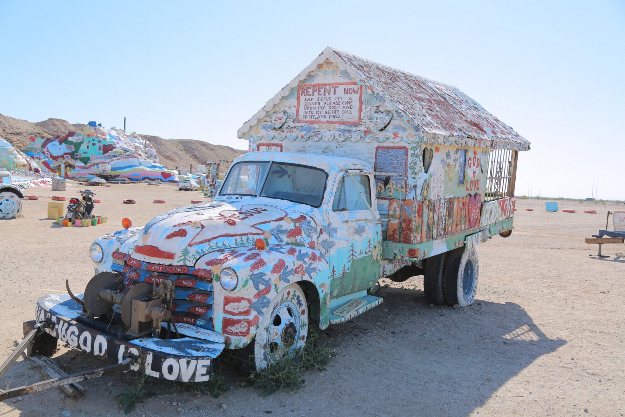 Outsider art of a painted truck and building at Salvation Mountain, California.