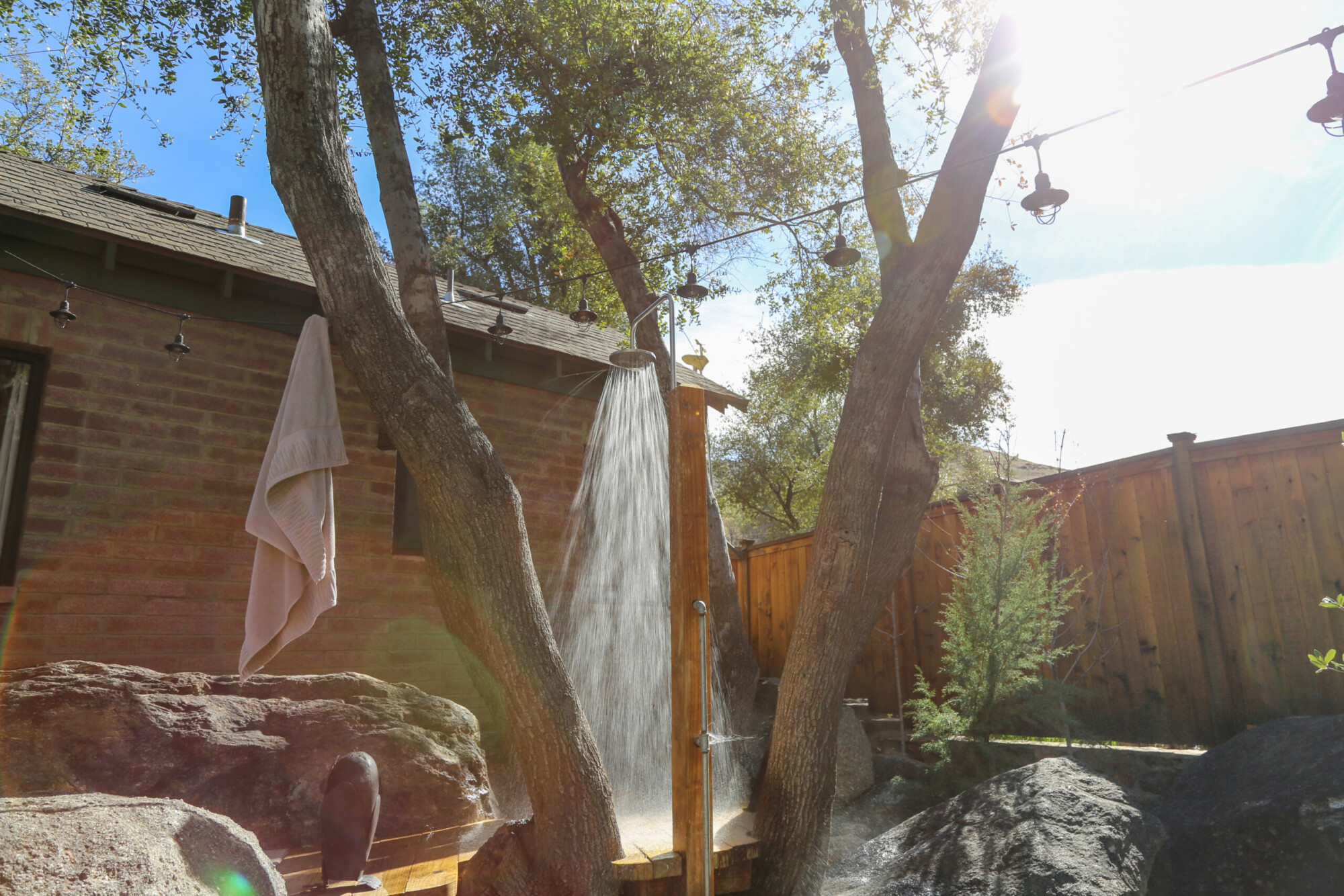 Outdoor Shower set in a cluster of tree trunks at Kern River House's River Willow Cabin in Kernville, California.