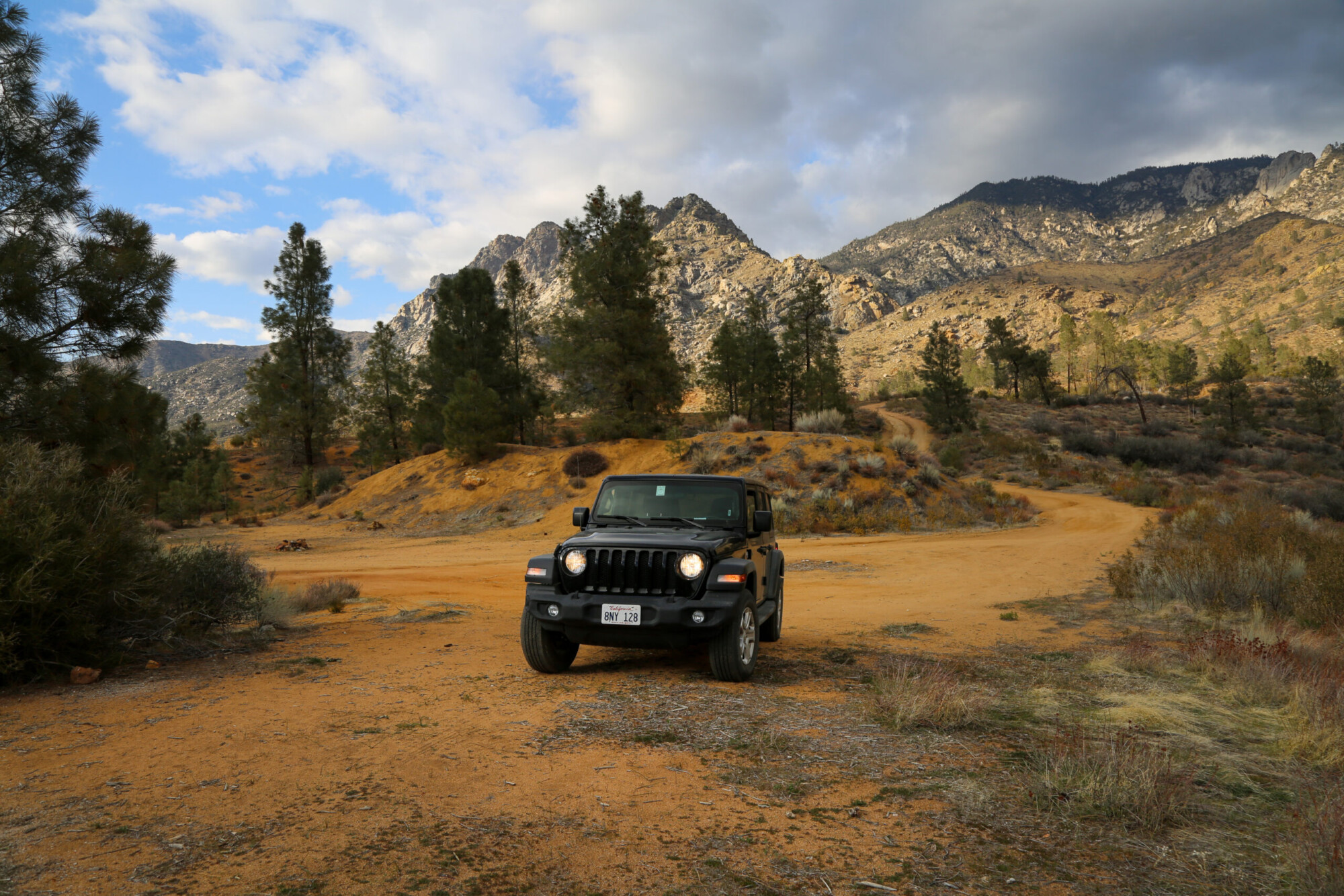 Photo of a black Jeep off-roading in a hilly and sparse conifer landscape near Kernville, California.