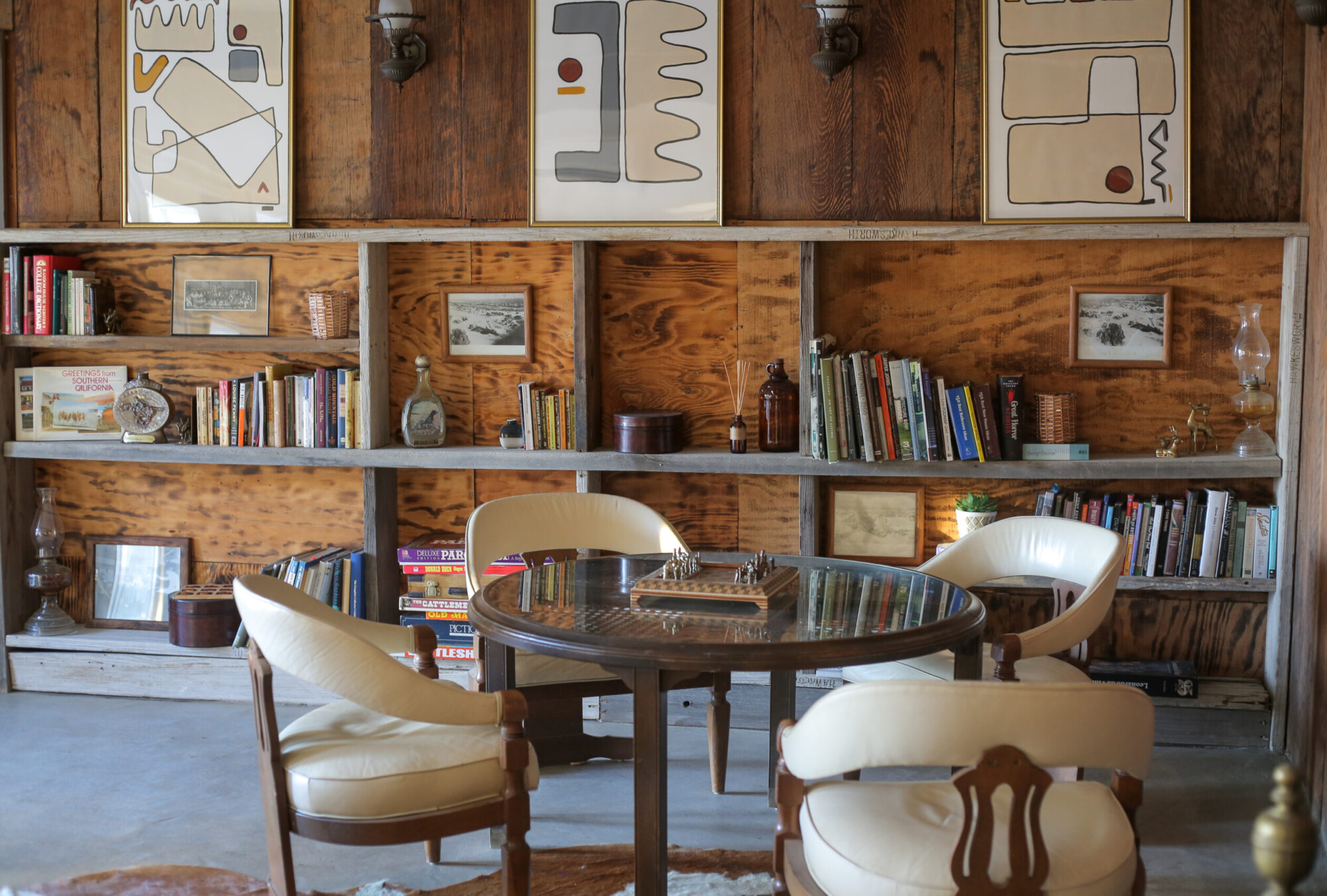 Interiors of the lobby with books, art, games, and a game table in the lobby at Cuyama Buckhorn in New Cuyama, California.