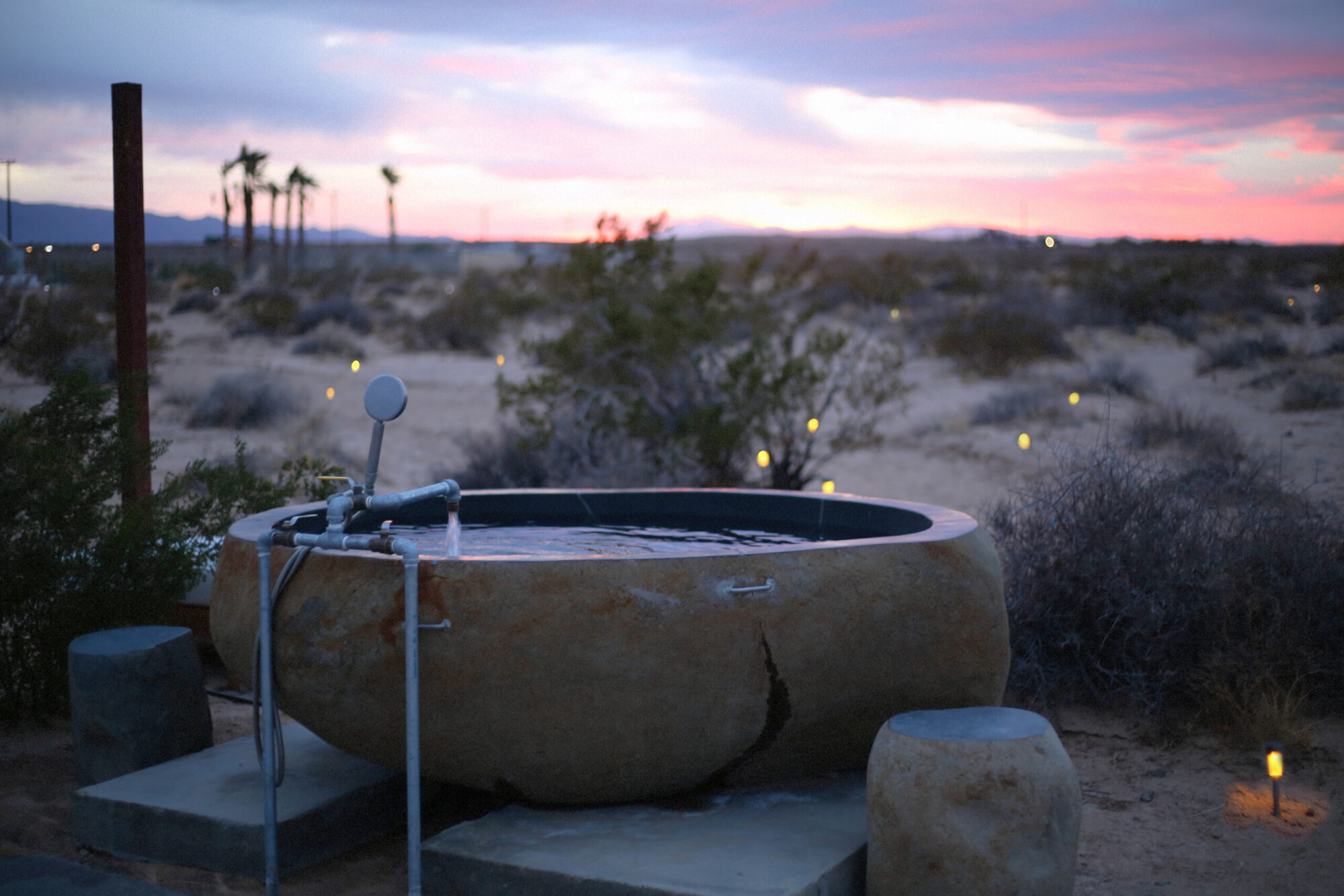 Sunset view of a hot springs tub at Ocotillo Oasis near Wonder Valley, California.